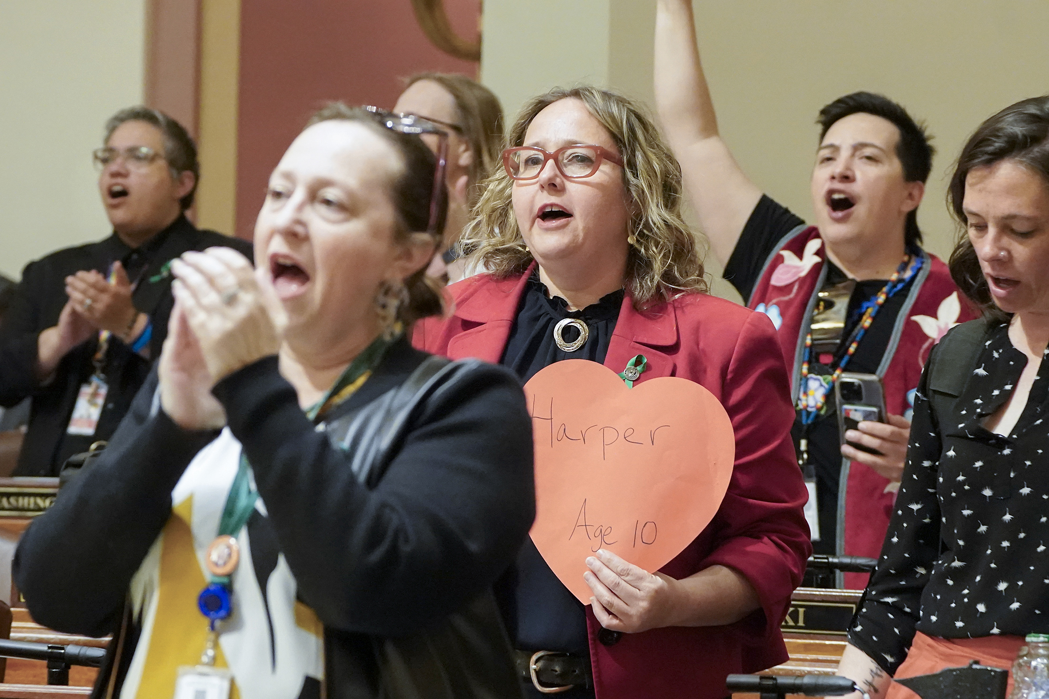 Rep. Emma Greenman holds a heart bearing the name of Annunciation School shooting victim Harper Moyski in the House Chamber following the start of a May 14 floor session recess. Greenman was joined by her DFL colleagues chanting for a chance to debate and vote on the gun control package passed by the Senate last week. (Photo by Michele Jokinen)
